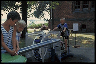 Mittels einer Grundwasserpumpe fördern Kinder in spielerischer Form Grundwasser, z.B.: Versorgungssysteme(Aquädukte).